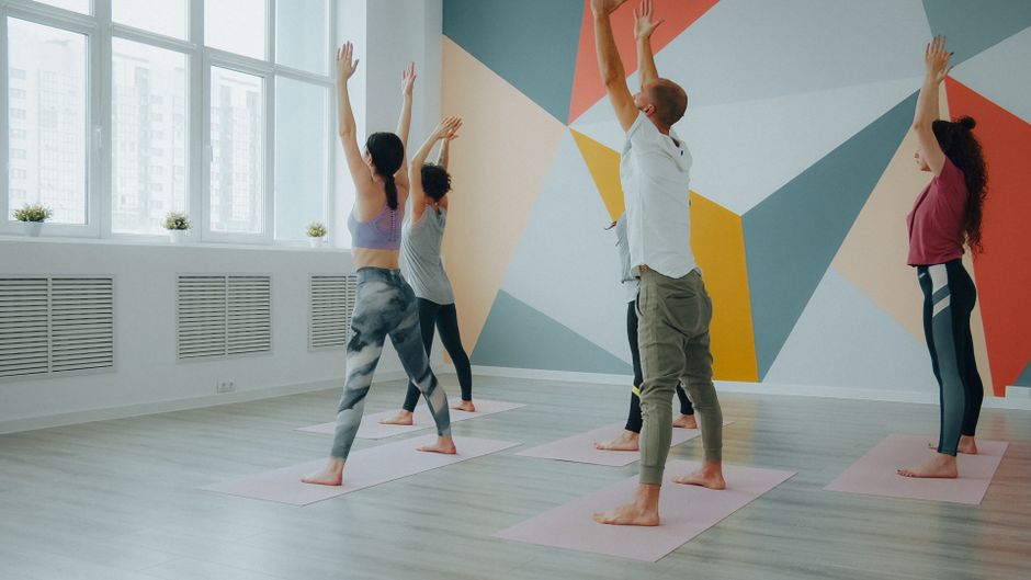 Yoga class practising together in a bright studio
